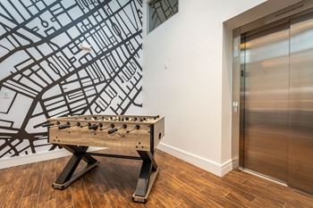 A foosball table in a room with an elevator